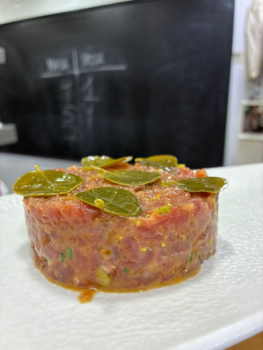 Tartare gastronomique garni de feuilles de câprier grecques et herbes fraîches